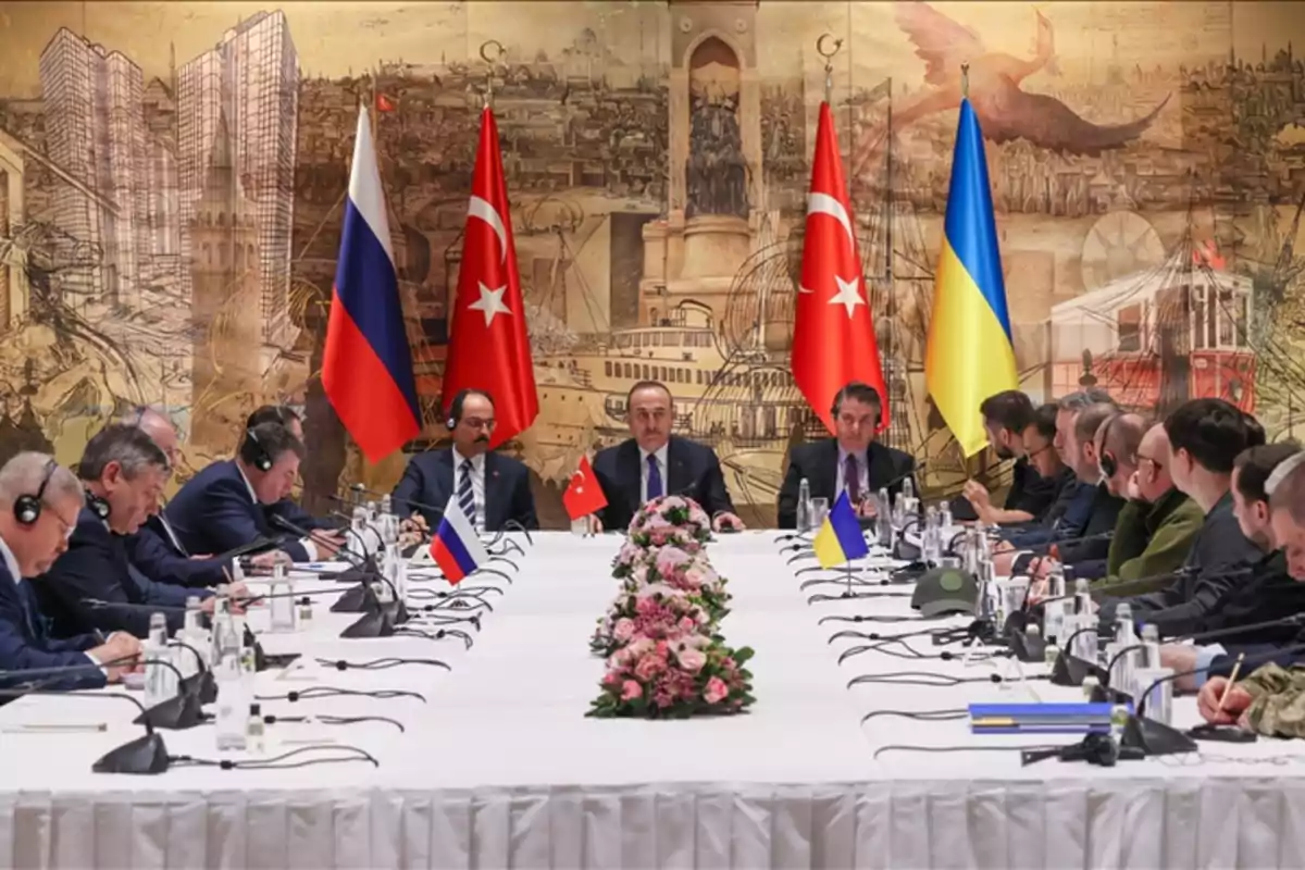 A diplomatic meeting with representatives from several countries sitting around a table with flags of Russia, Türkiye, and Ukraine in the background. A diplomatic meeting with representatives from several countries sitting around a table with flags of Russia, Türkiye, and Ukraine in the background.