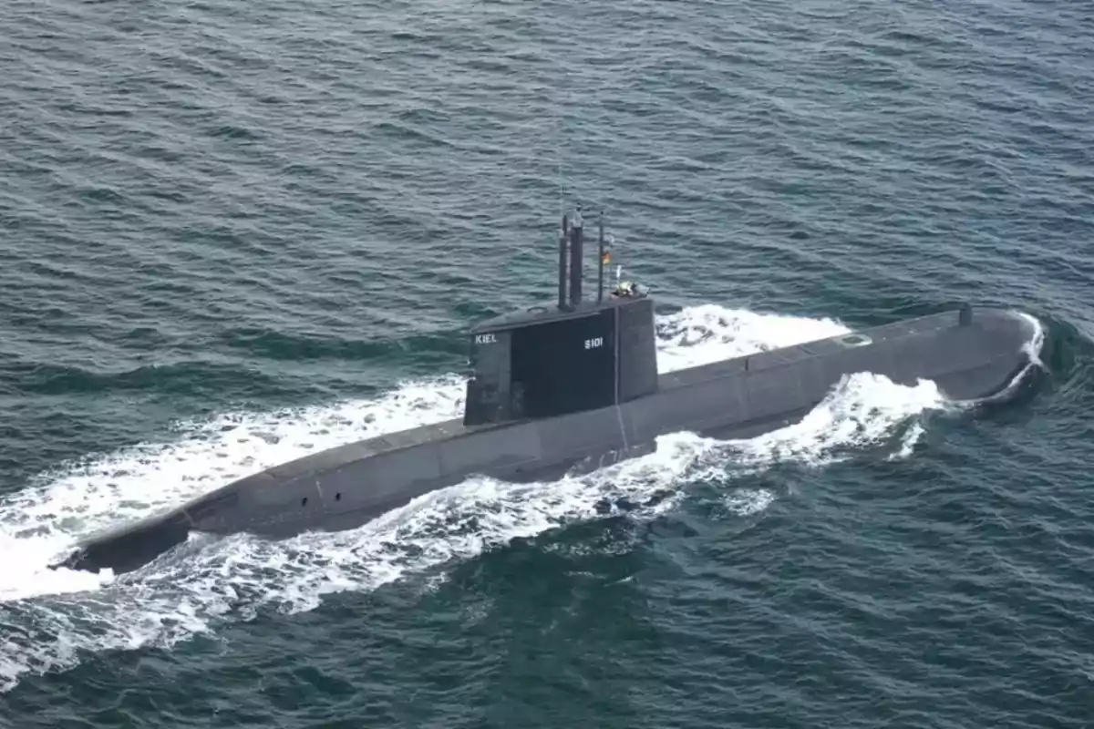 Submarino navegando en el océano con olas rompiendo a su alrededor.