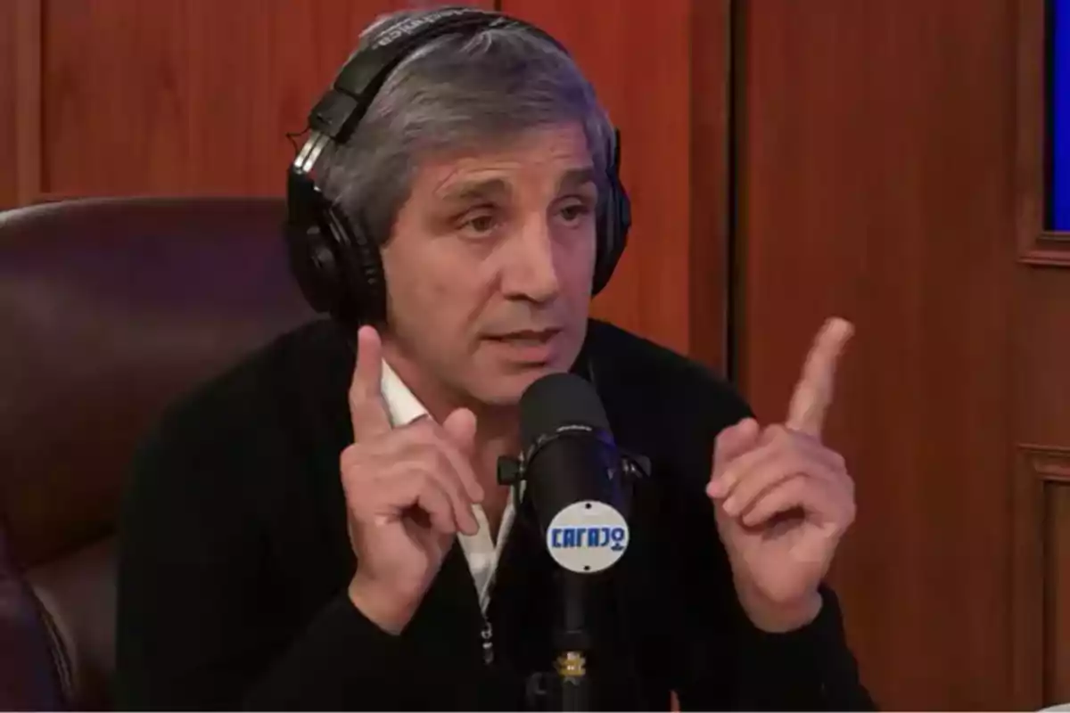 A man with headphones speaks in front of a microphone in a radio studio.