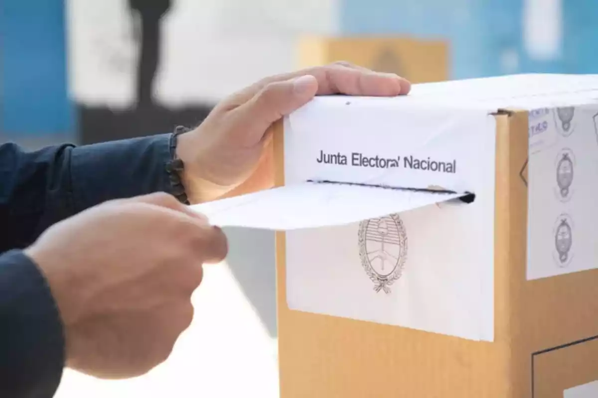 Una persona introduce un sobre en una urna de votación de la Junta Electoral Nacional.