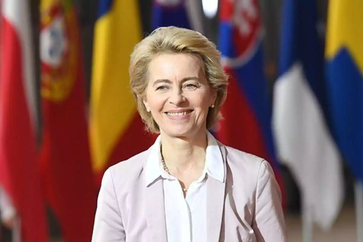 Una persona sonriendo con banderas de varios países en el fondo. Una persona sonriendo con banderas de varios países en el fondo.