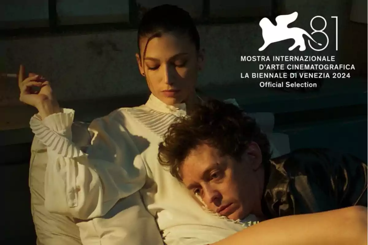 A woman in a white blouse holds a cigarette while a man rests his head on her lap, with the Venice Film Festival 2024 logo in the top right corner. A woman in a white blouse holds a cigarette while a man rests his head on her lap, with the Venice Film Festival 2024 logo in the top right corner.