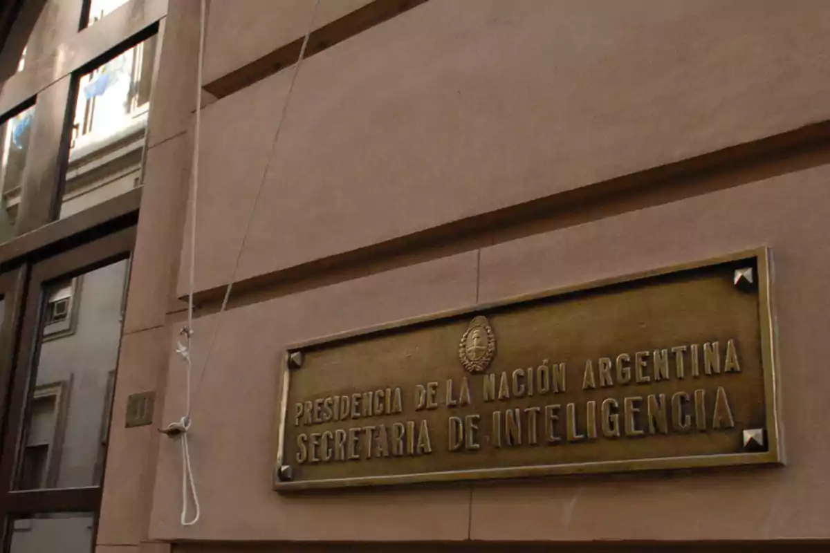 Placa dorada en la pared de un edificio que dice "Presidencia de la Nación Argentina Secretaría de Inteligencia".