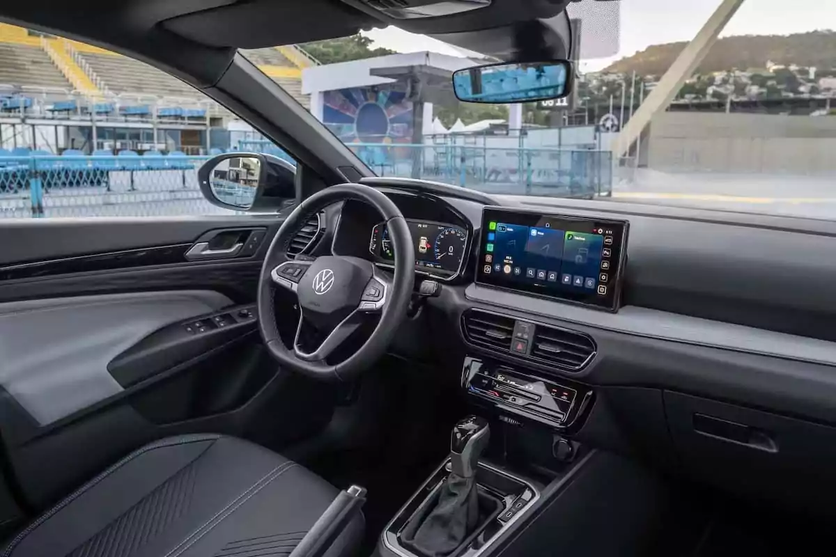 Interior of a Volkswagen car with a steering wheel, touchscreen, and leather seats, parked near a stadium. Interior of a Volkswagen car with a steering wheel, touchscreen, and leather seats, parked near a stadium.