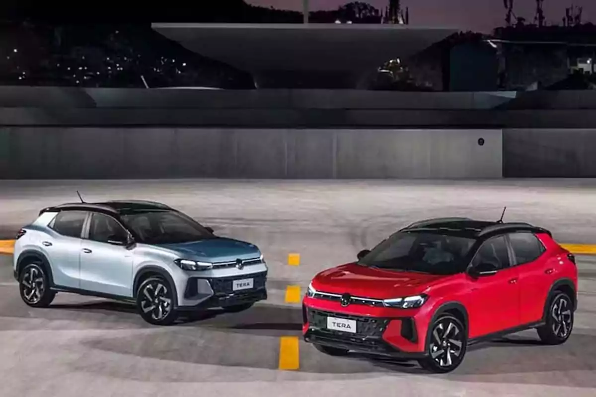 Two SUV cars parked in an open area, one blue and the other red, with an urban background at dusk. Two SUV cars parked in an open area, one blue and the other red, with an urban background at dusk.