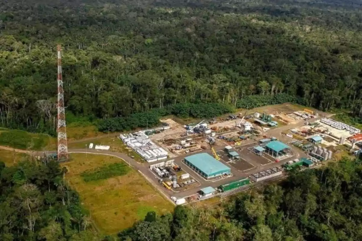 Aerial view of an industrial facility surrounded by dense tropical forest.