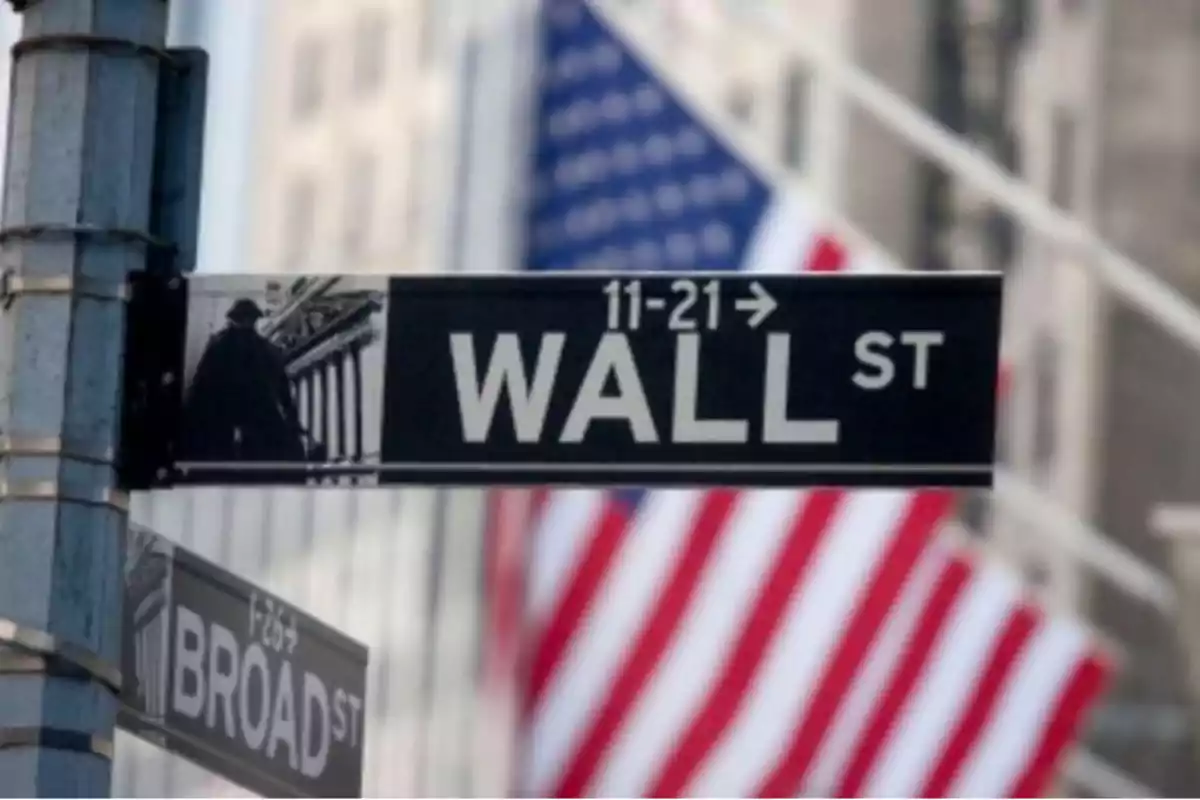 Señal de Wall Street con una bandera de Estados Unidos de fondo.