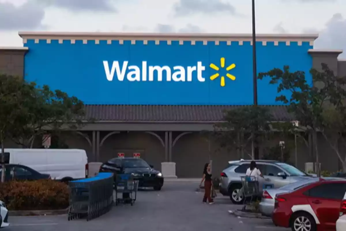 Fachada de una tienda Walmart con estacionamiento y carros de compras.