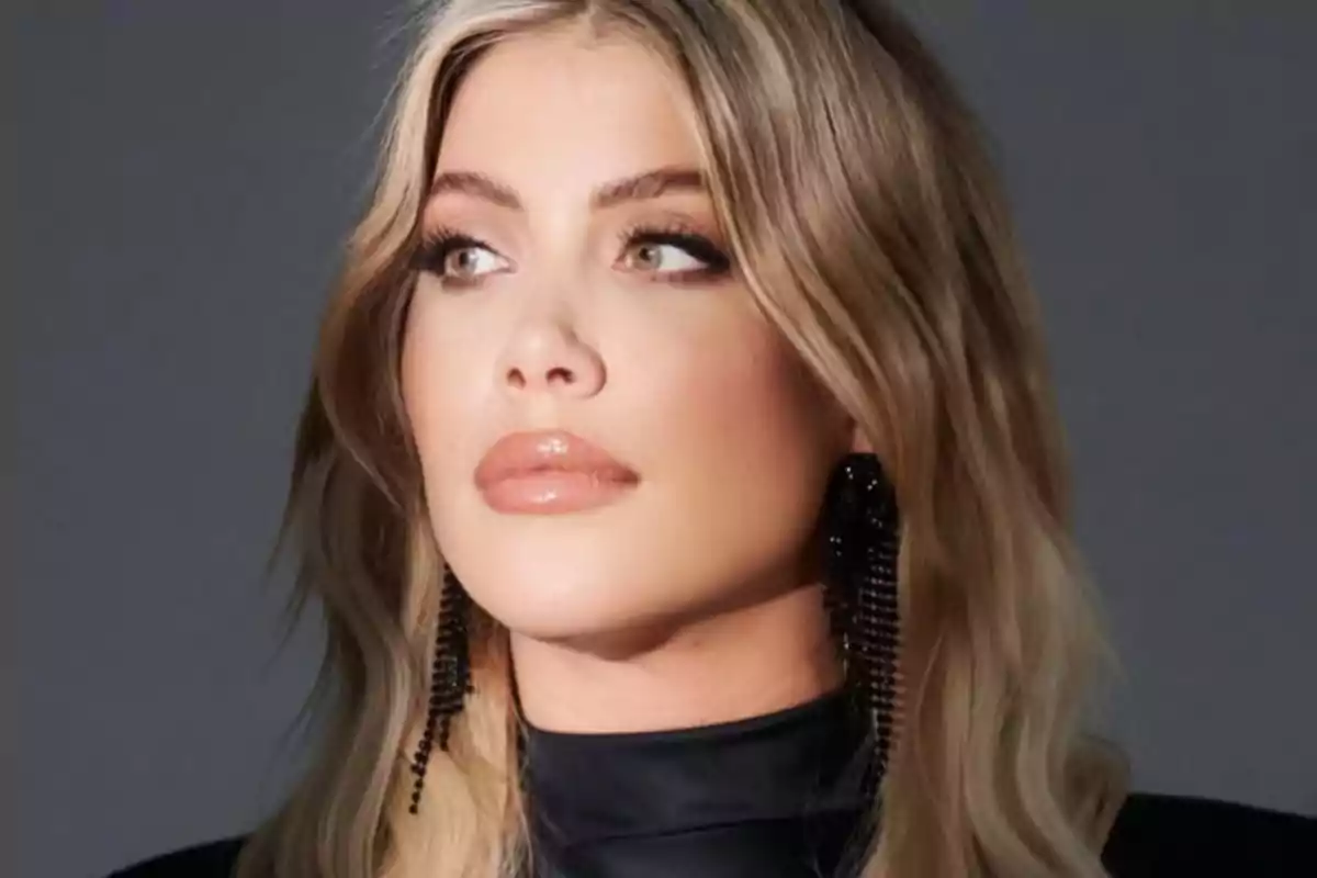 A person with blonde hair and elegant makeup looking to the side.