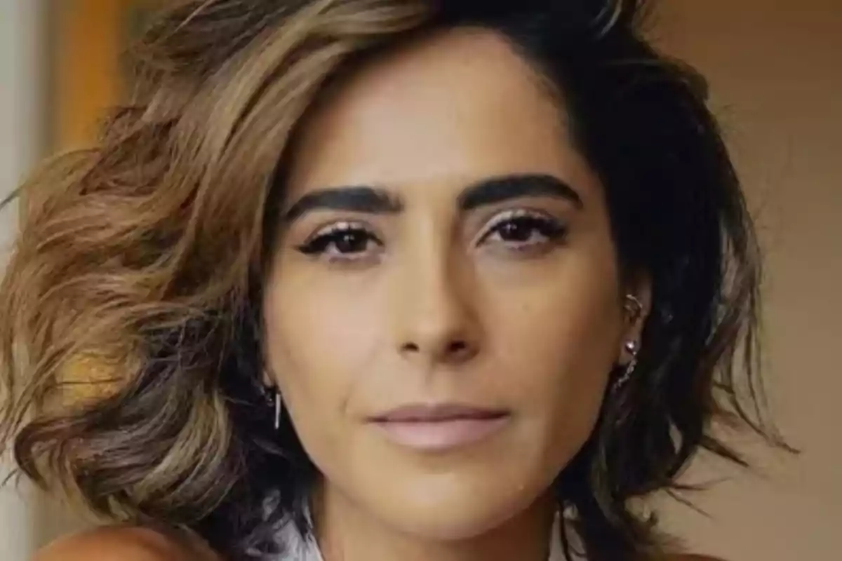 A person with wavy brown hair looking at the camera. A person with wavy brown hair looking at the camera.