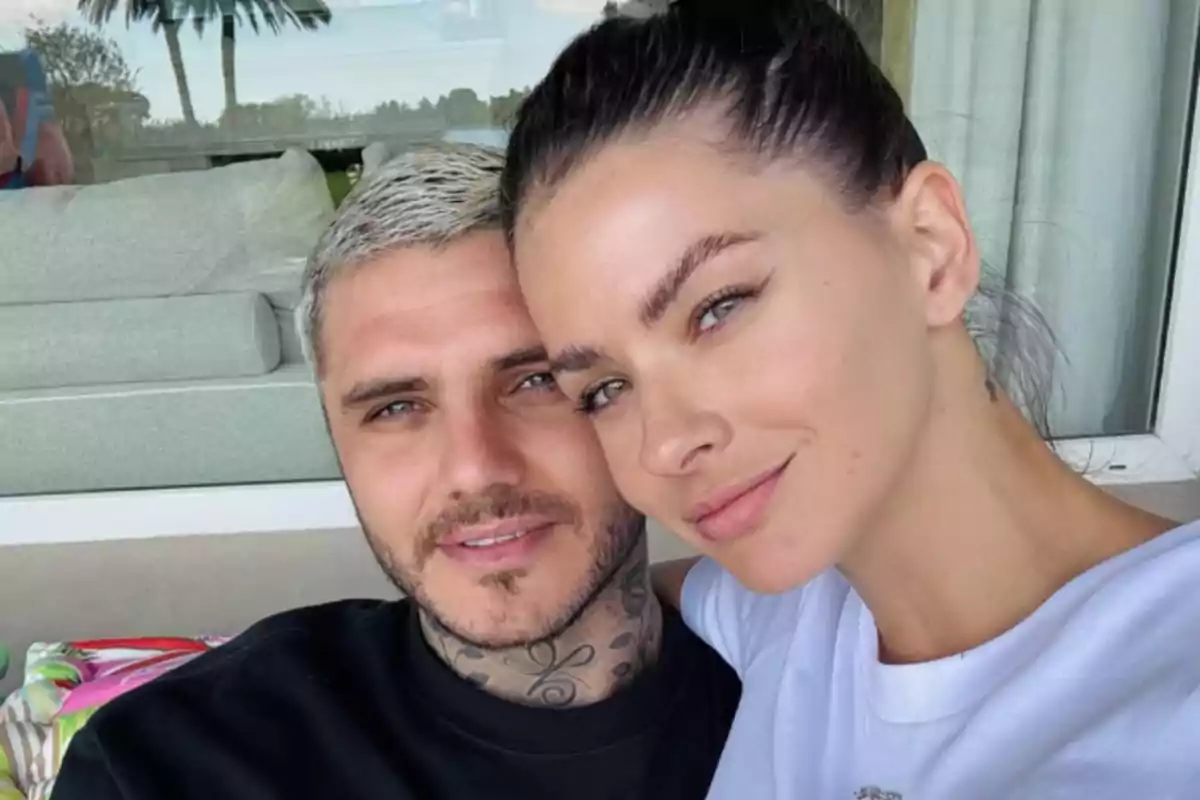 Pareja joven tomándose una selfie juntos en un ambiente al aire libre con fondo de palmeras y ventanales Pareja joven tomándose una selfie juntos en un ambiente al aire libre con fondo de palmeras y ventanales