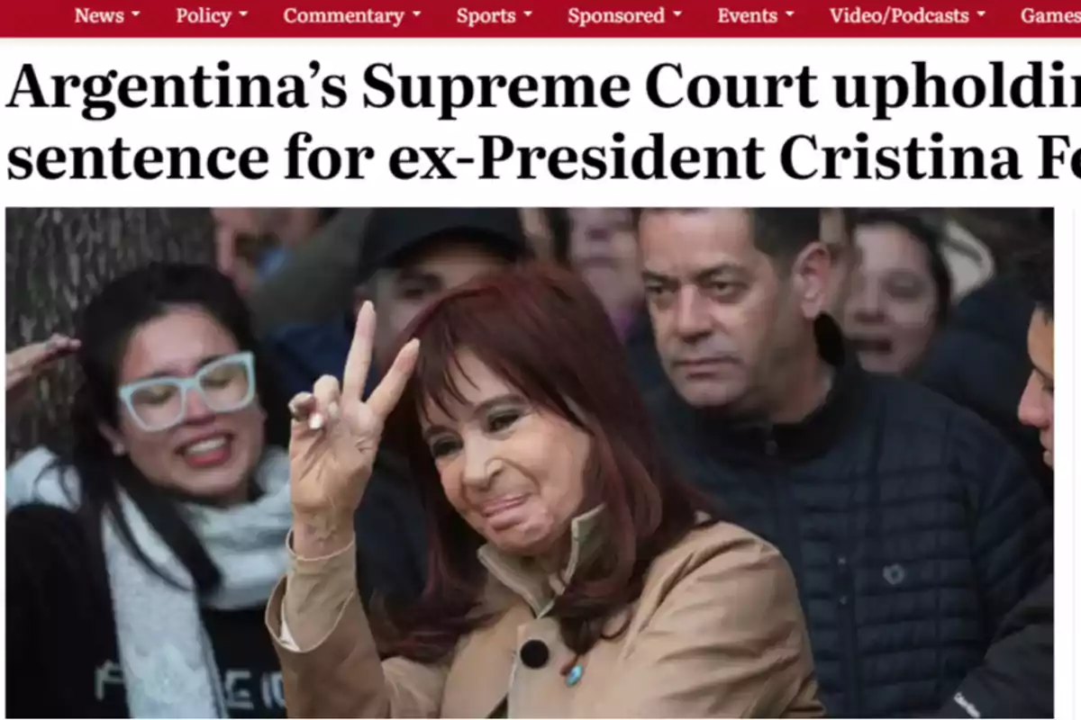 Red-haired woman making the victory sign with her fingers while smiling and surrounded by people Red-haired woman making the victory sign with her fingers while smiling and surrounded by people