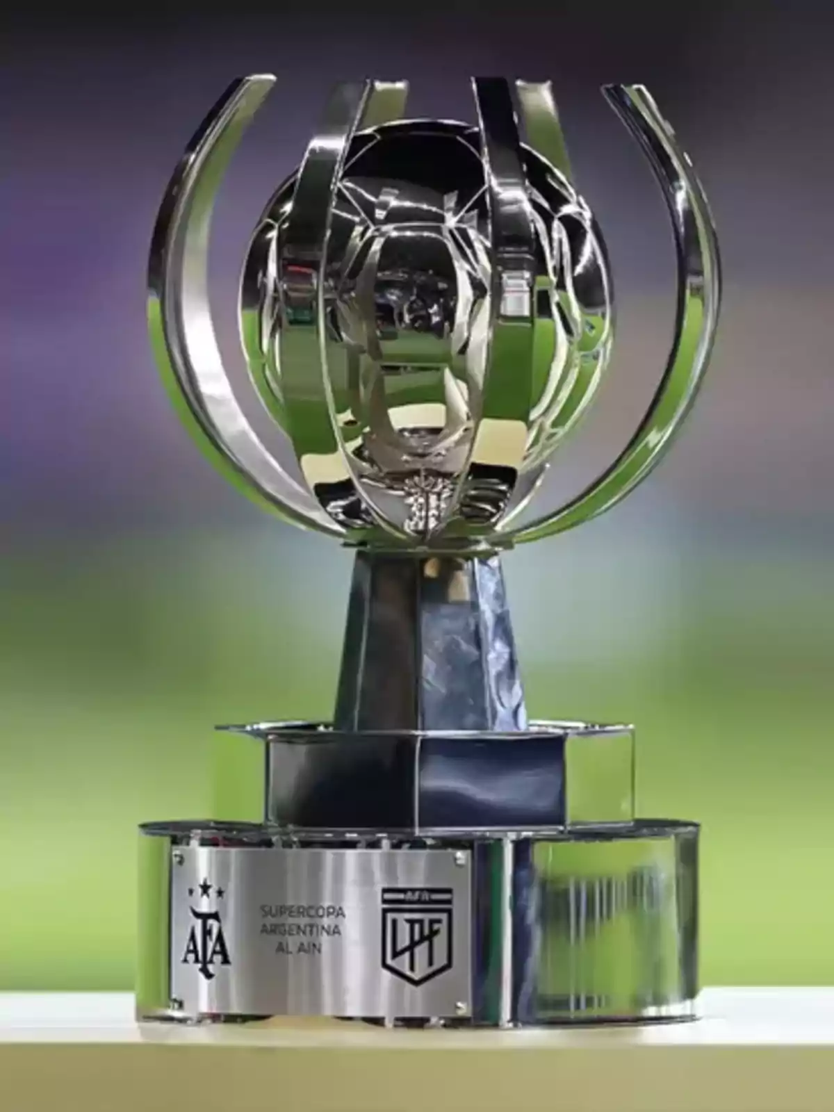 Argentine Super Cup trophy with a modern and shiny design against a blurred background.