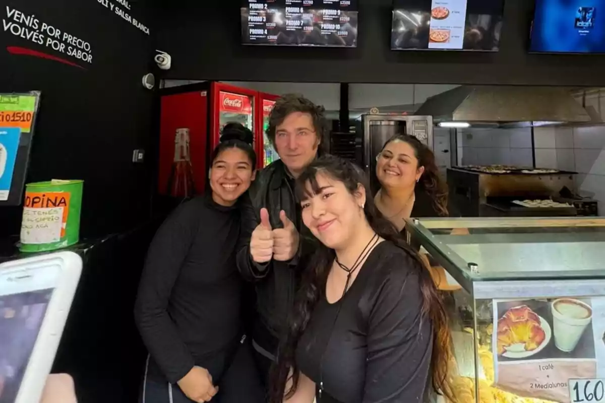 Un grupo de personas sonríe mientras posa para una foto en el interior de un local de comida.