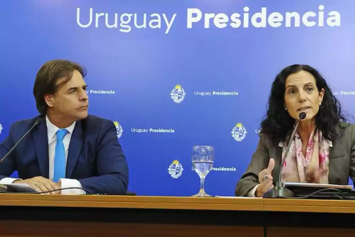 Dos personas en una conferencia de prensa con un fondo azul que dice "Uruguay Presidencia".