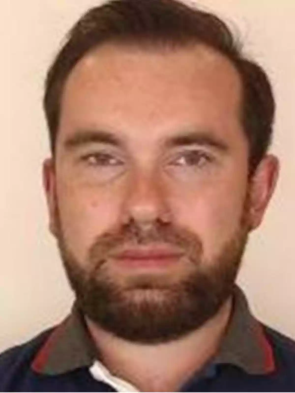 Short-haired man with a beard looking straight ahead with a serious expression Short-haired man with a beard looking straight ahead with a serious expression
