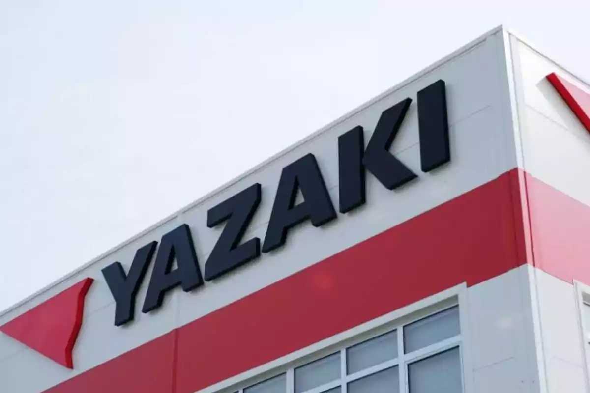 Edificio con el logotipo de Yazaki en letras negras sobre una fachada blanca y roja.