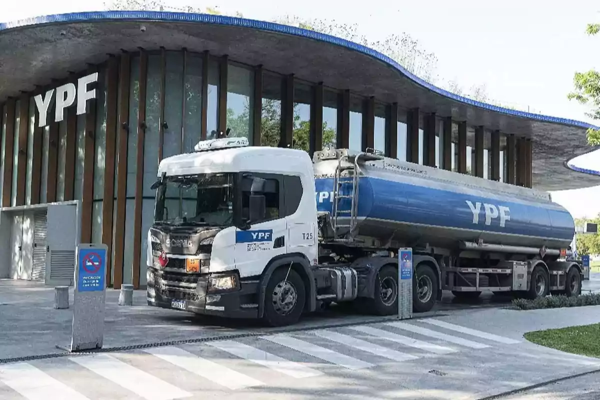 A YPF tanker truck parked in front of a modern building of the same company. A YPF tanker truck parked in front of a modern building of the same company.