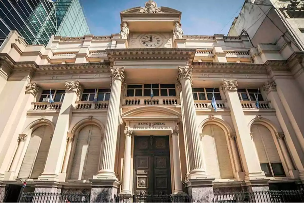 Edificio histórico con columnas y reloj en la fachada.