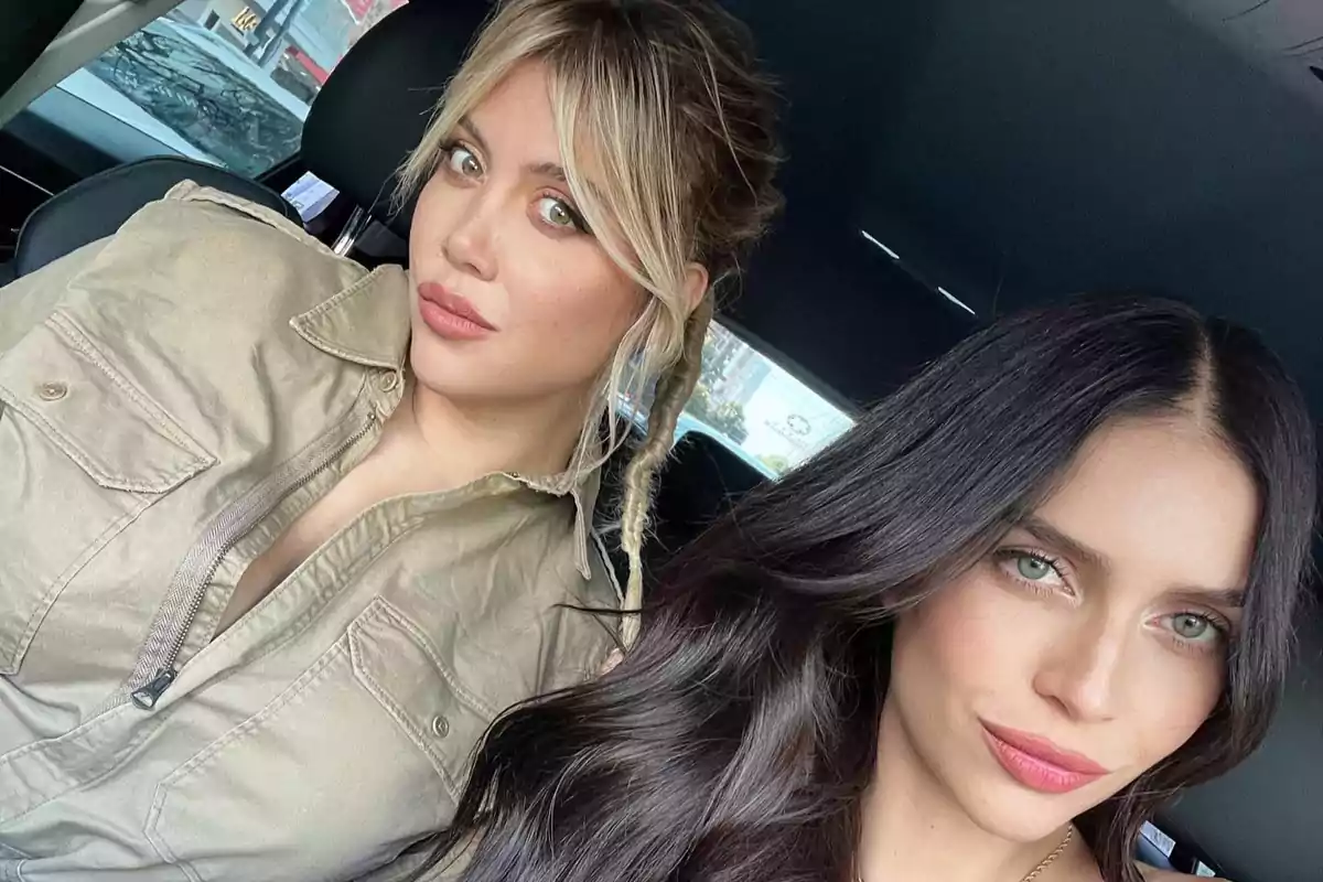 Two young women pose for a selfie inside a car, both looking at the camera with serious expressions and wearing their hair down. Two young women pose for a selfie inside a car, both looking at the camera with serious expressions and wearing their hair down.