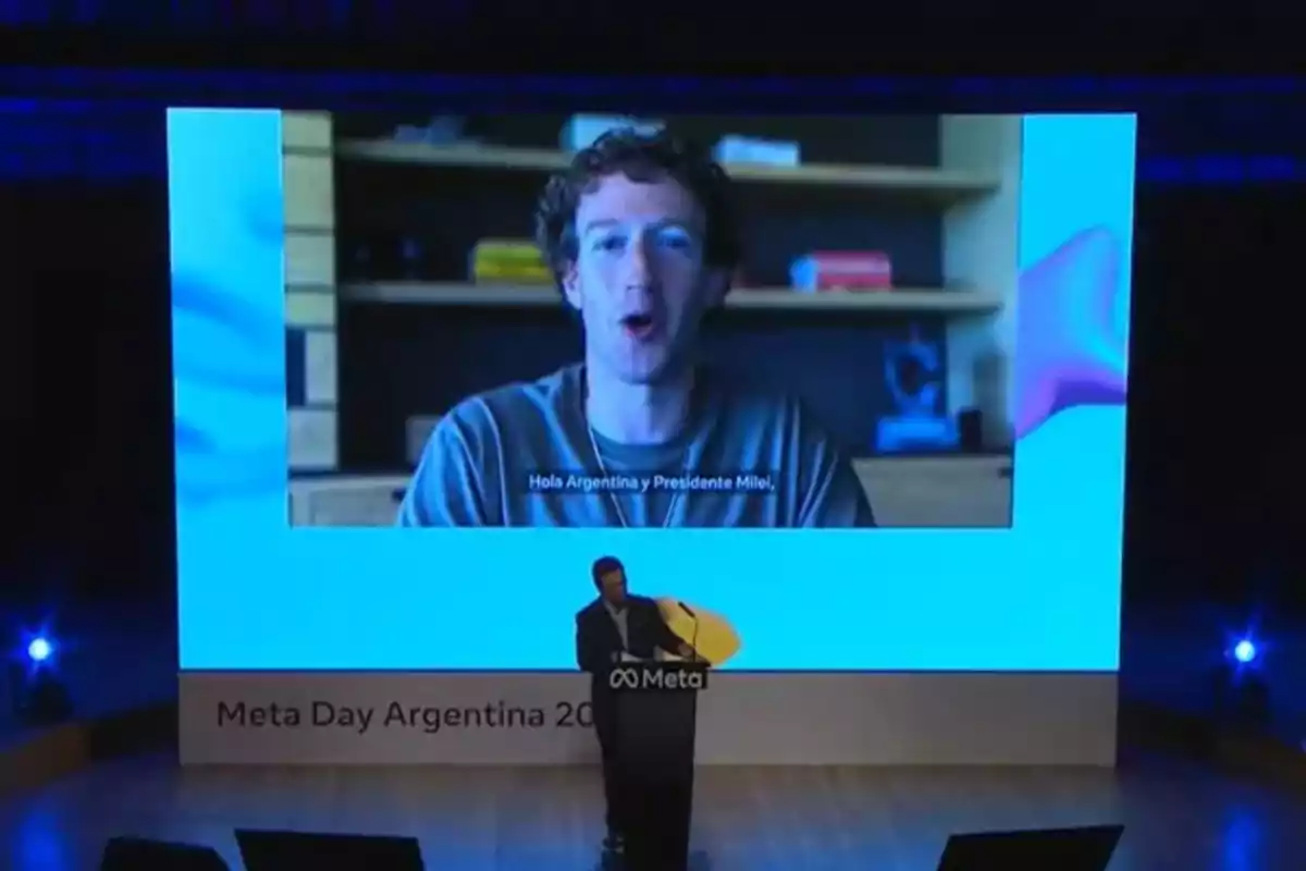 Un hombre en un escenario presenta un video en una pantalla grande durante el evento Meta Day Argentina 2023.